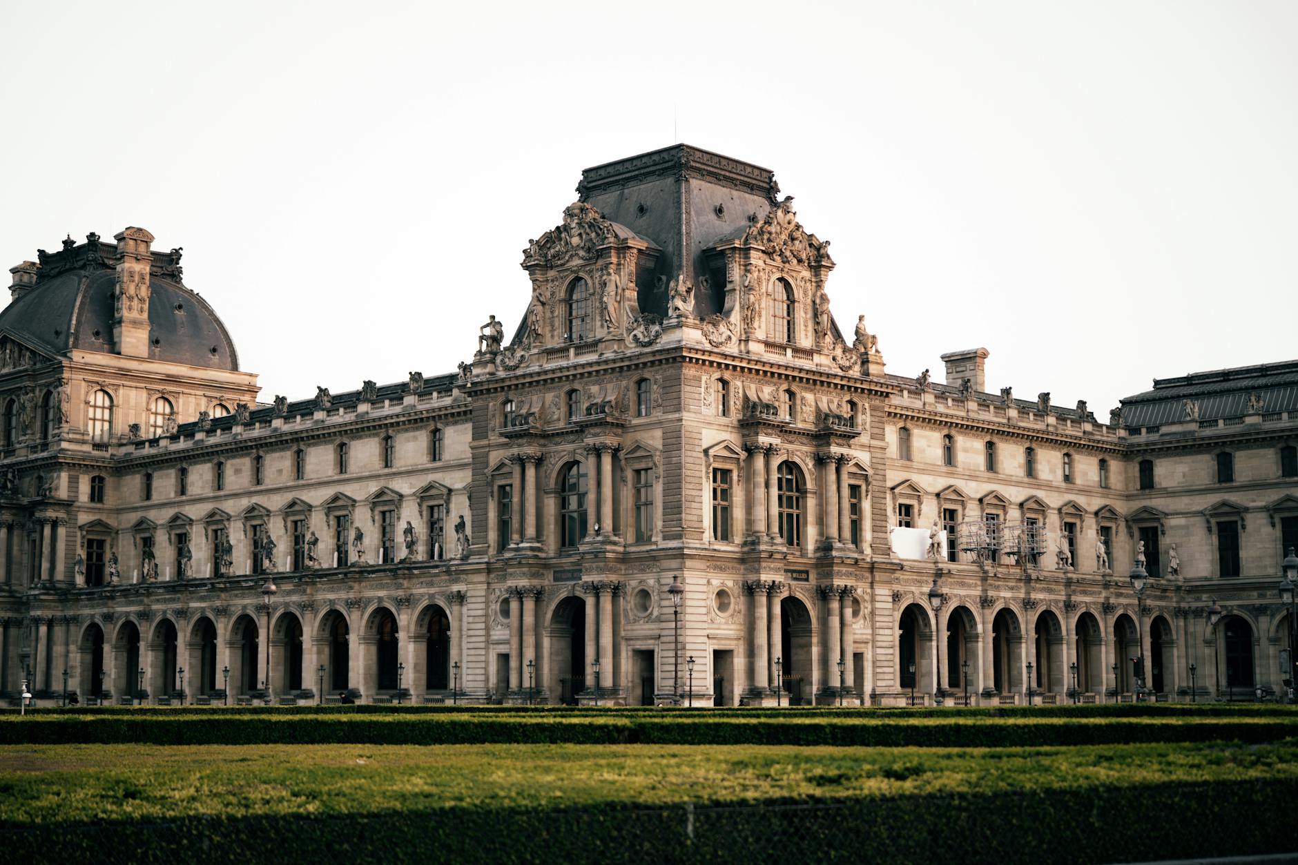 Elegant view of the historic Louvre Museum in Paris, showcasing its grand architecture at dusk.