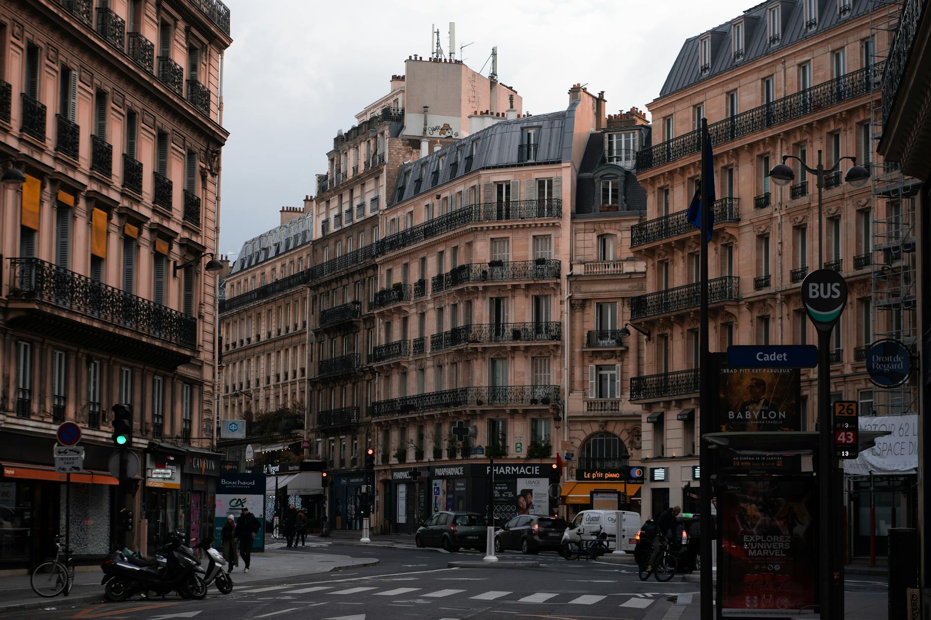 Charming Paris street intersection with classic Haussmann architecture and bustling city life.