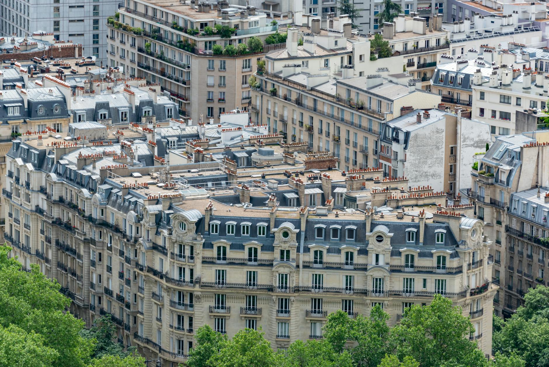 Discover the classic Haussmannian architectural style of Parisian rooftops and facades from a high angle view.