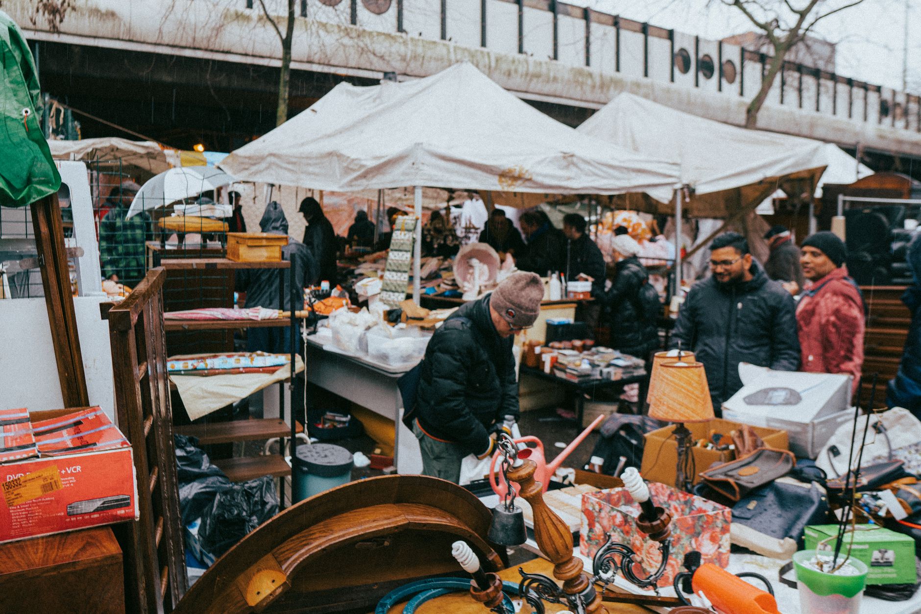 Explore the lively atmosphere of a Paris flea market on a chilly winter day, showcasing diverse stalls and shoppers.