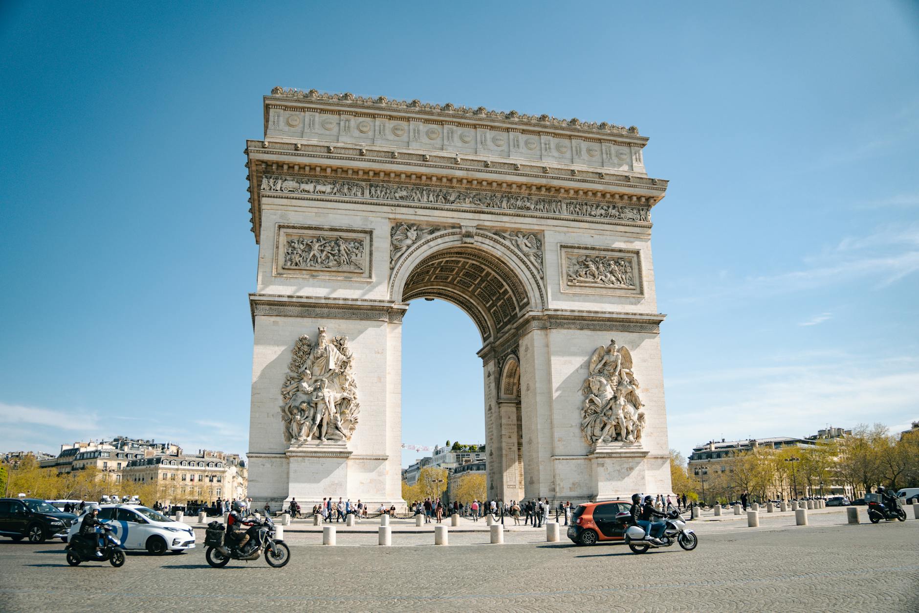 Iconic Arc de Triomphe under a clear blue sky in Paris, France, capturing the essence of French architecture.