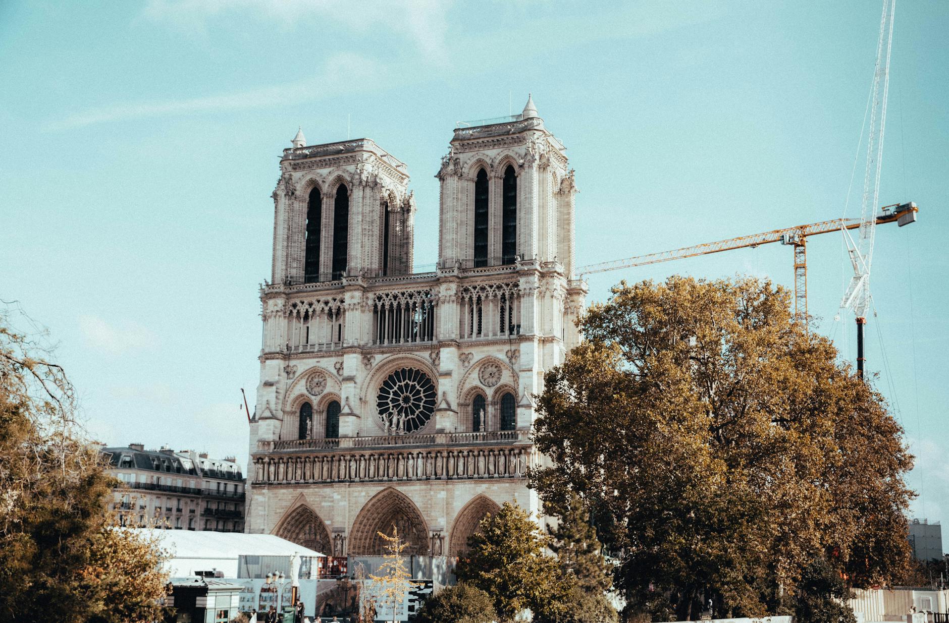 View of the iconic Notre Dame Cathedral in Paris during restoration work with cranes visible.