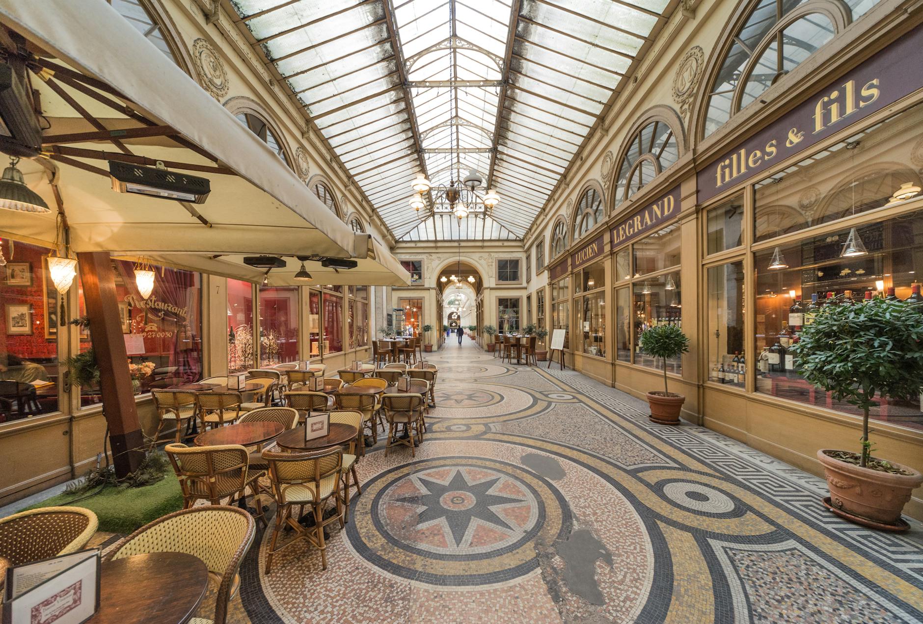 Discover the charm of Paris in a classic passage with ornate architecture, inviting café tables, and vintage shops.