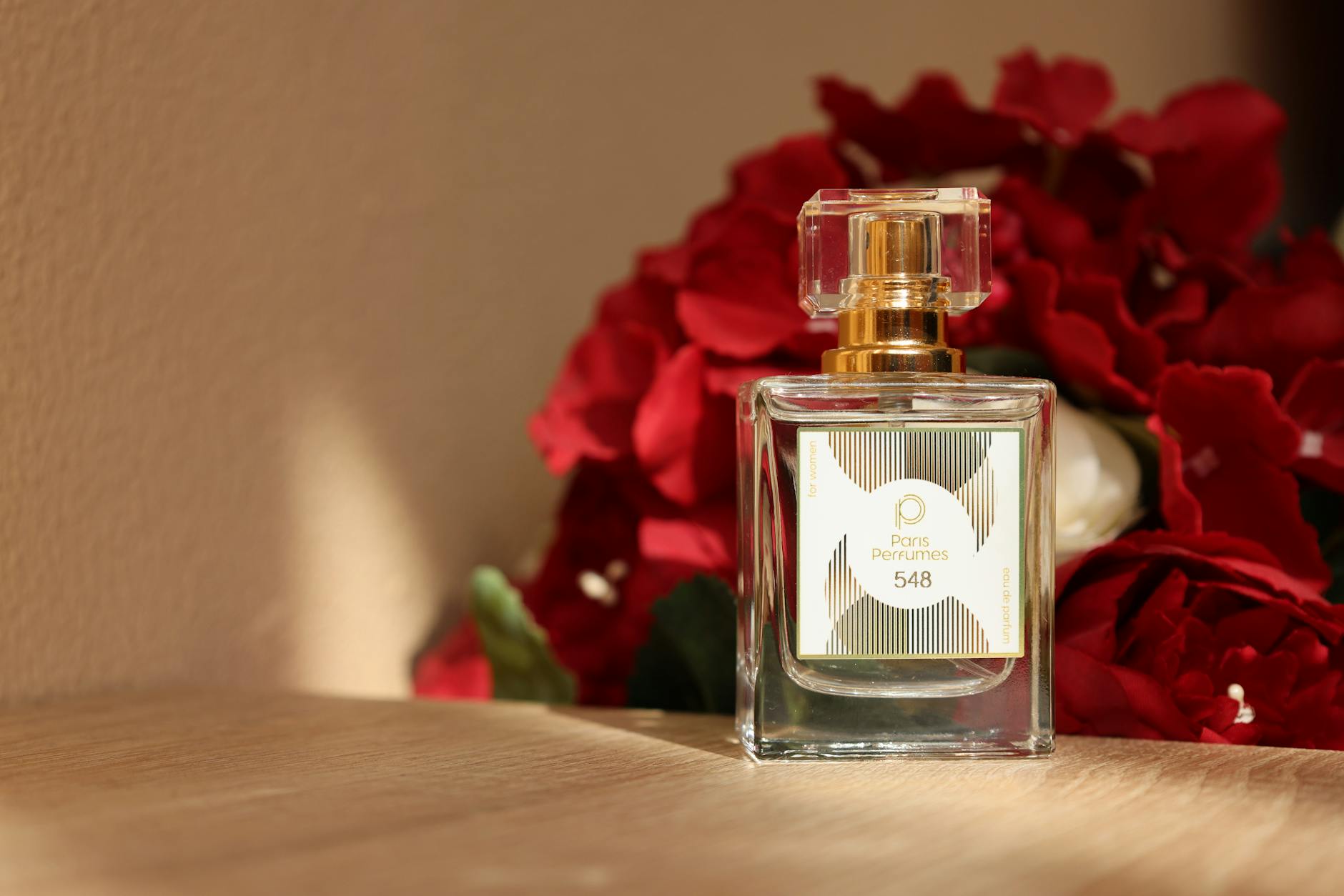 Elegant perfume bottle with red roses, embodying luxury and romance.