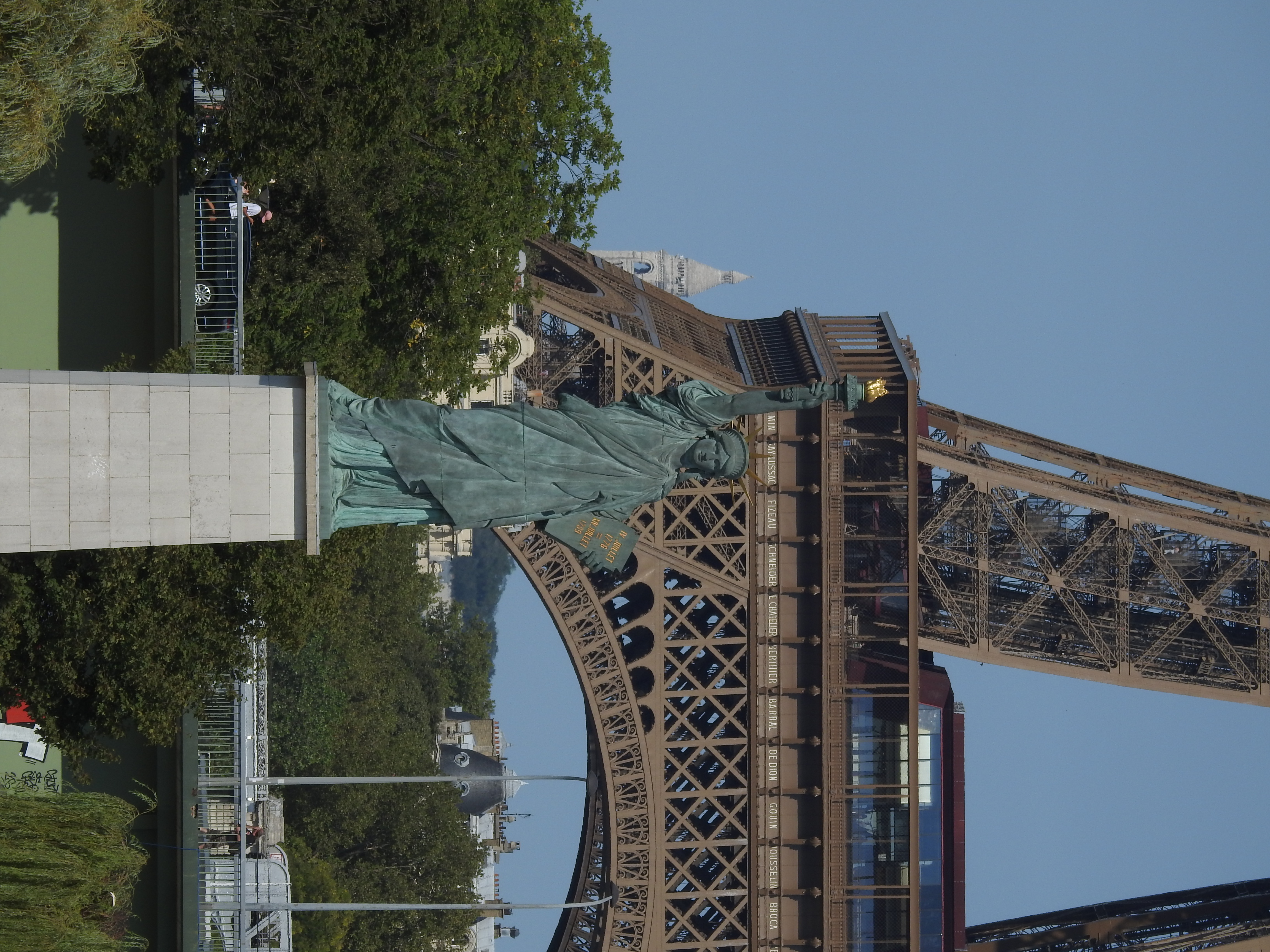 Statue of Liberty replica on Île aux Cygnes island in Paris with Seine river and Eiffel Tower in background