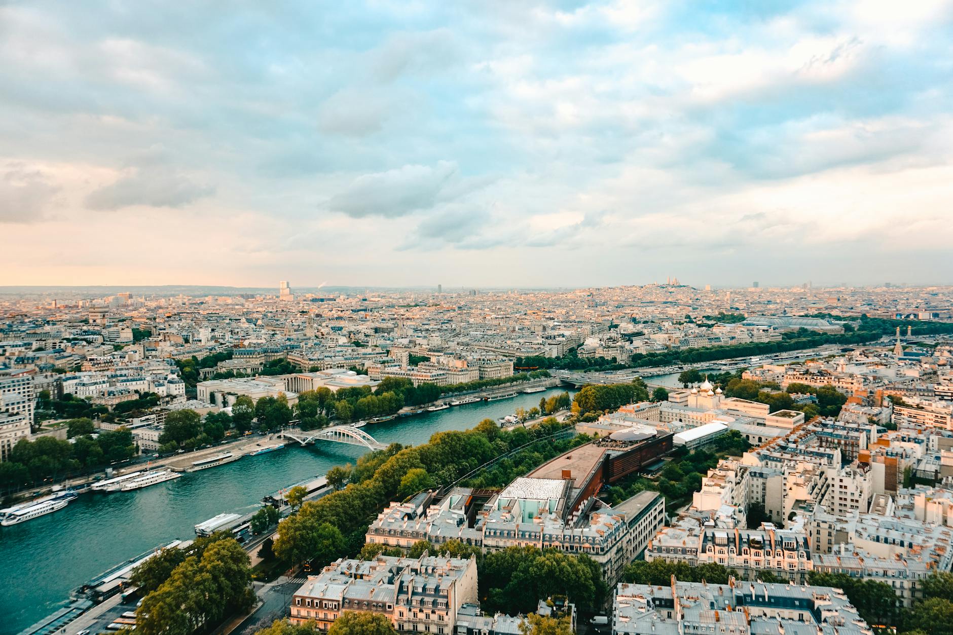 A stunning aerial view of Paris, showcasing the Seine River and iconic landmarks during sunset.
