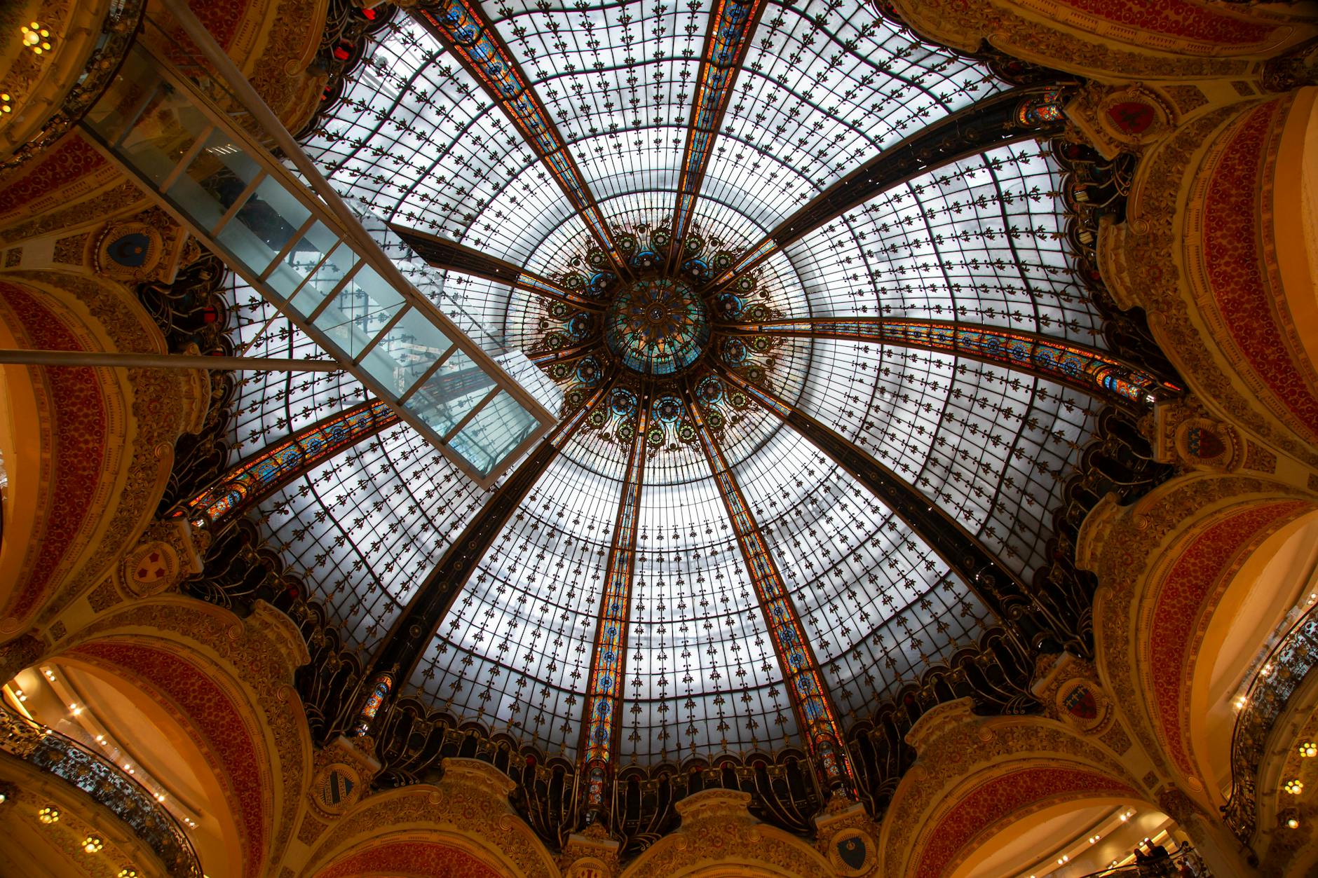 Ornate stained glass dome inside Galeries Lafayette, Paris.