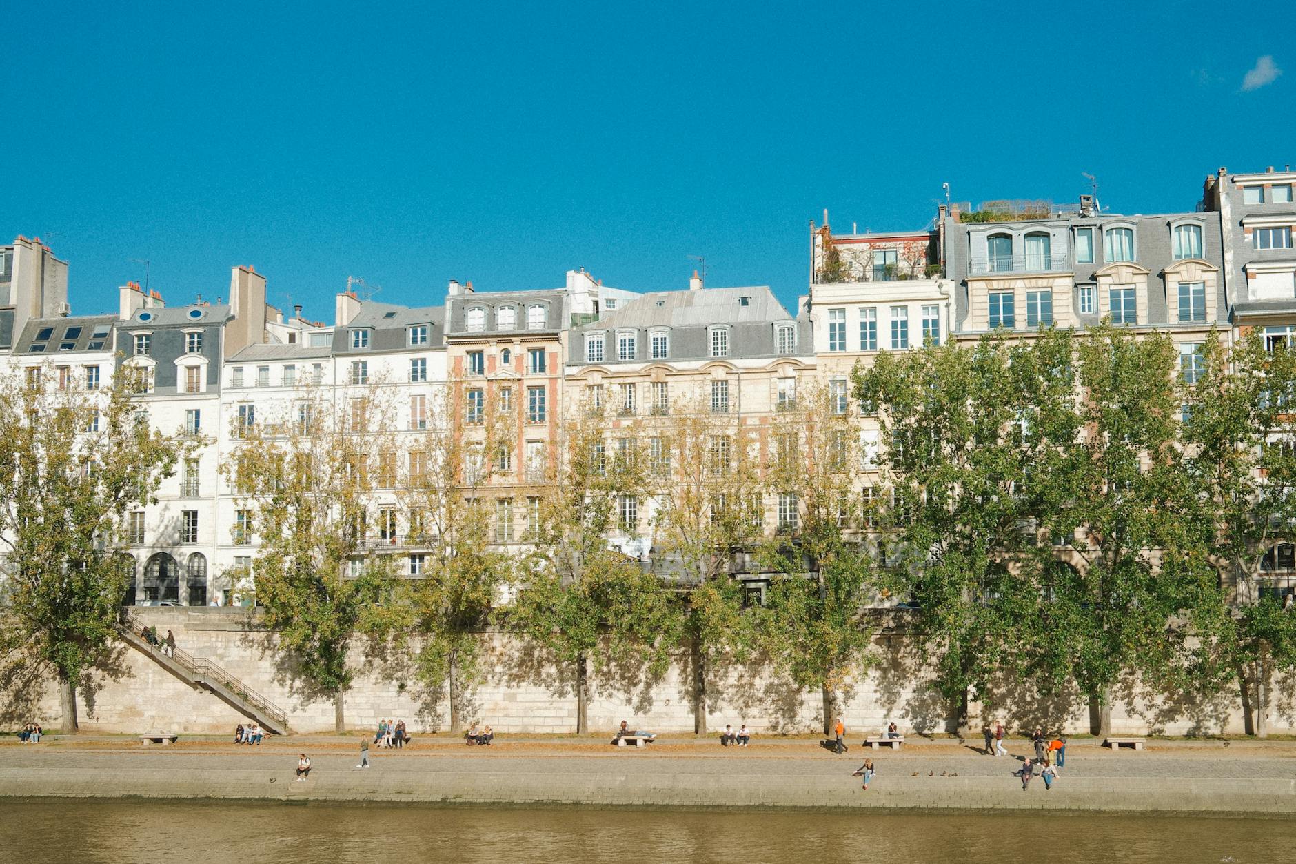 Charming view of Paris riverside with historic buildings under a clear blue sky.