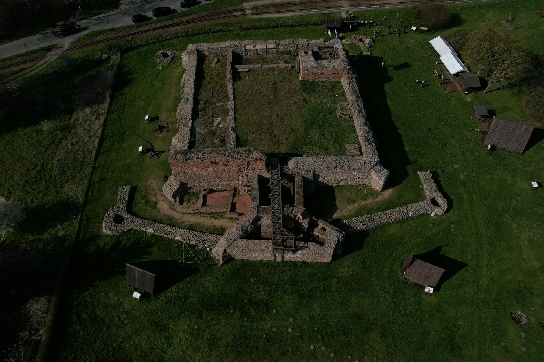 Aerial photograph showcasing the ancient stone ruins of a medieval castle in rural Poland.