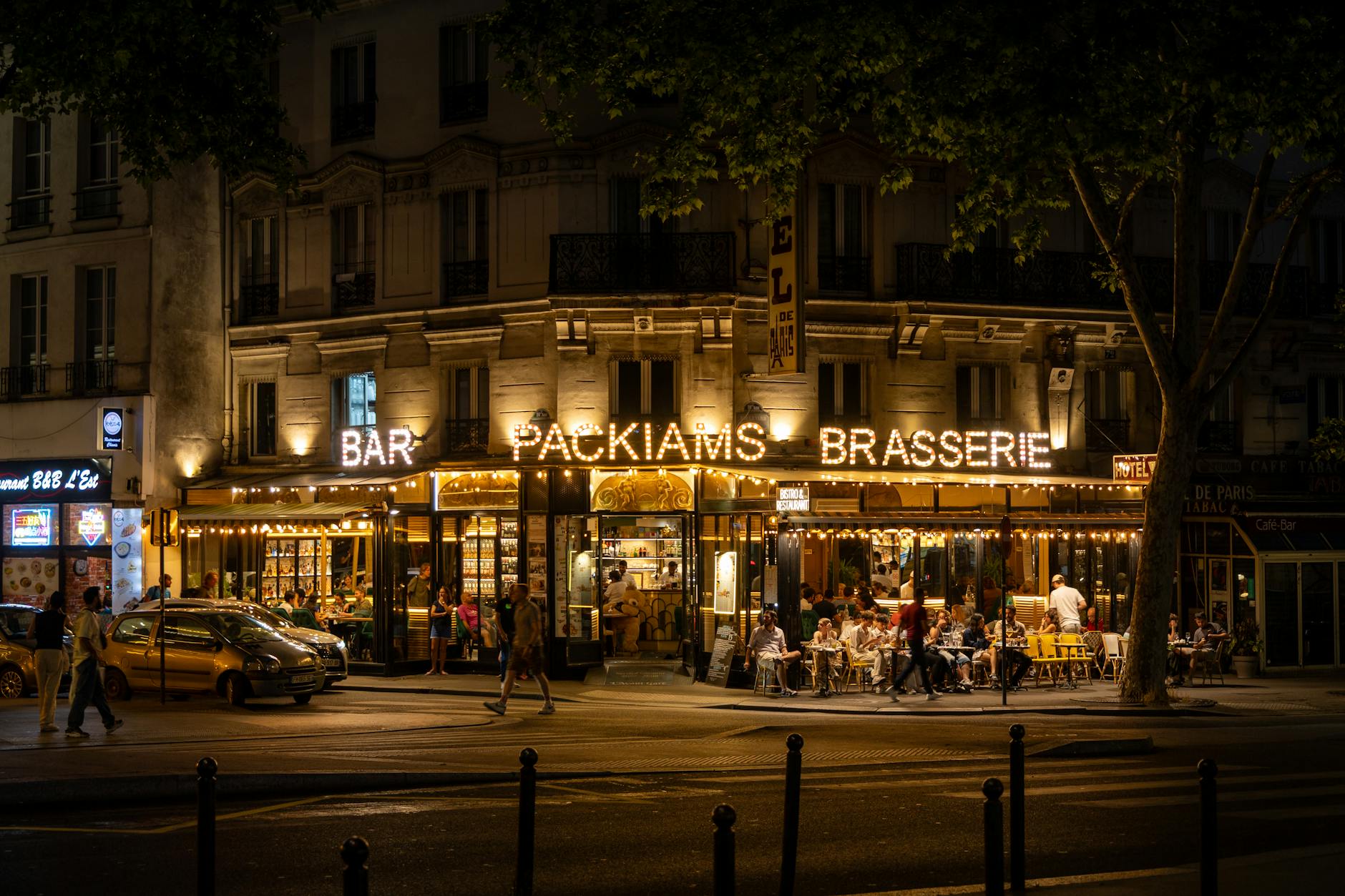 Packiams Brasserie lively evening scene in Paris, showcasing outdoor dining and vibrant nightlife.
