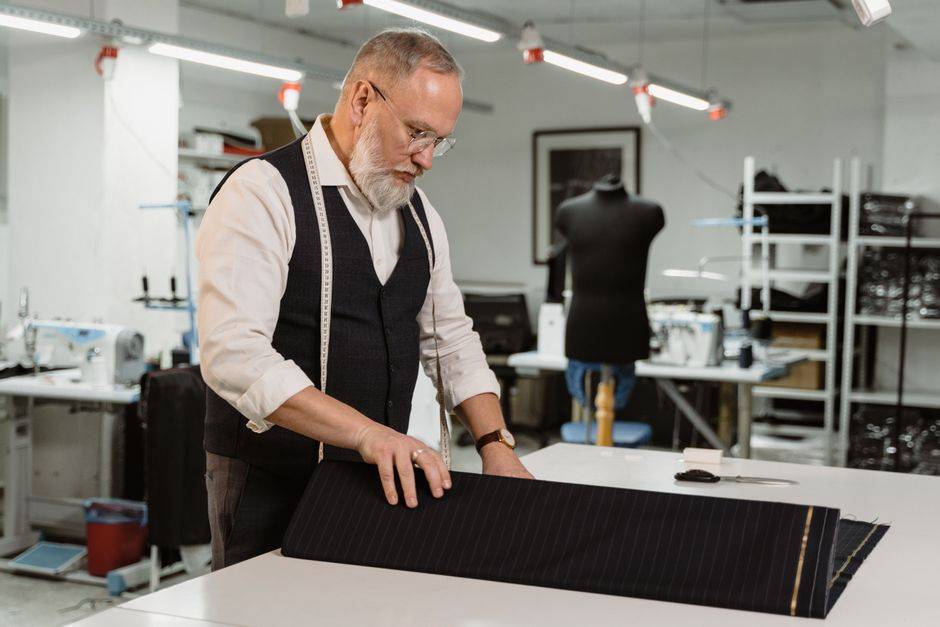 Fabric being cut in a tailoring workshop, illustrative photograph