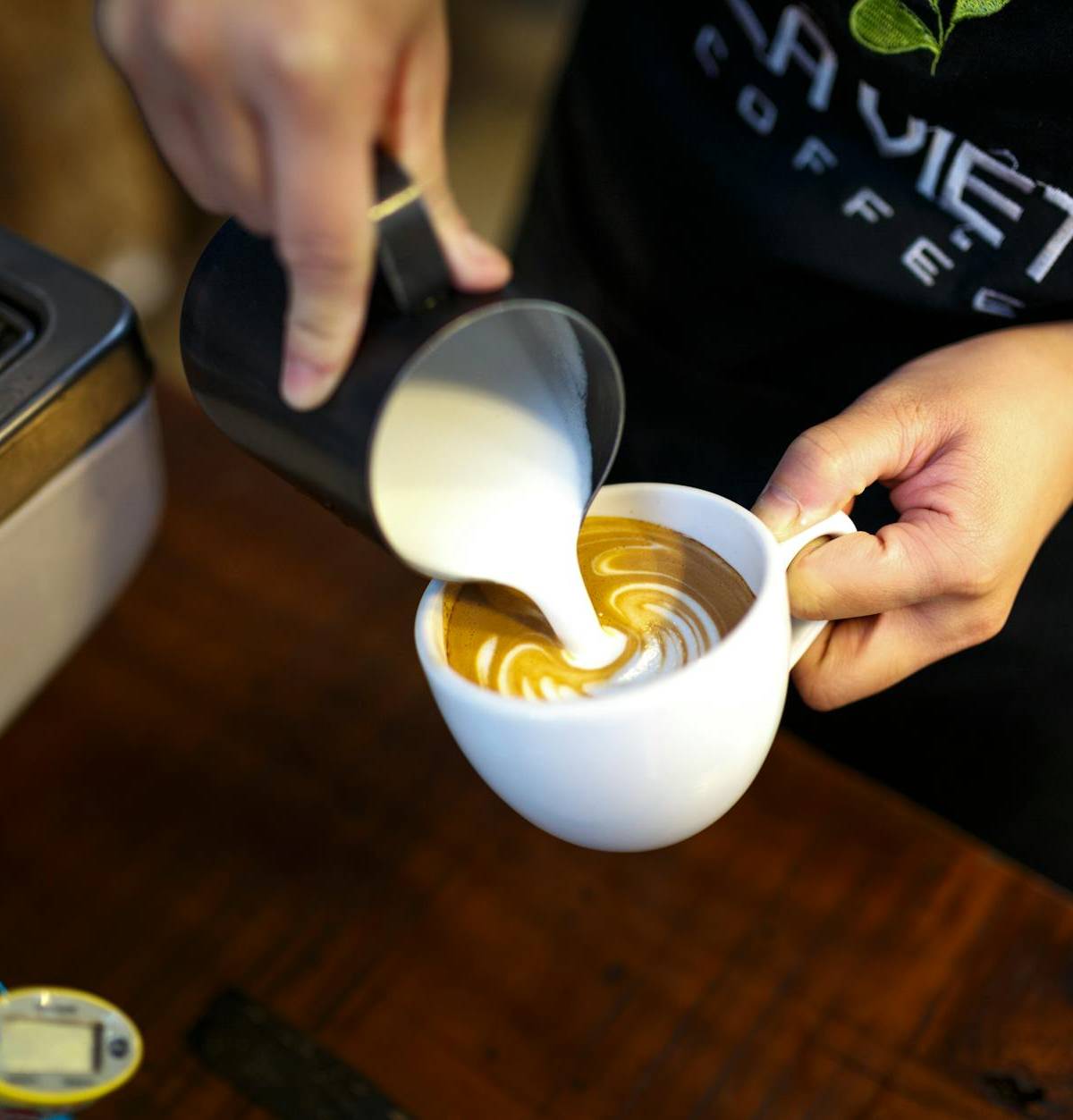 Milk being poured into espresso, illustrative photograph