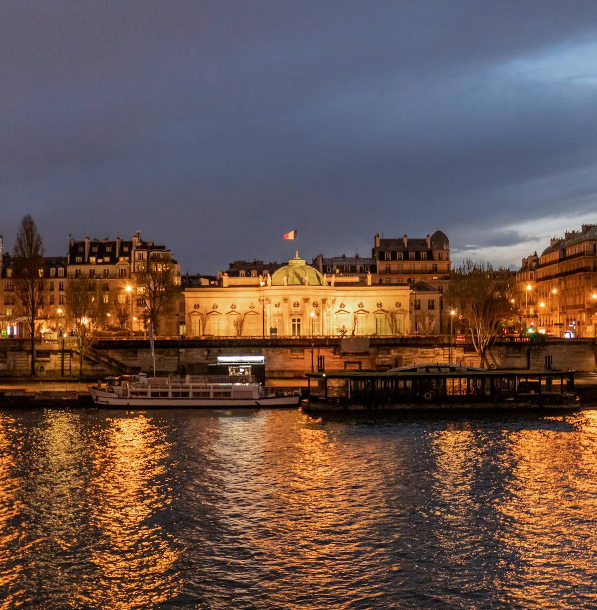 Paris riverfront buildings illuminated after dark