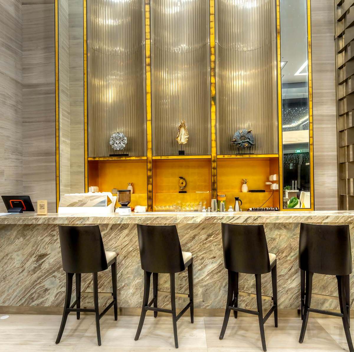 A luxurious and modern bar counter with stylish stools in a hotel's elegant interior design.
