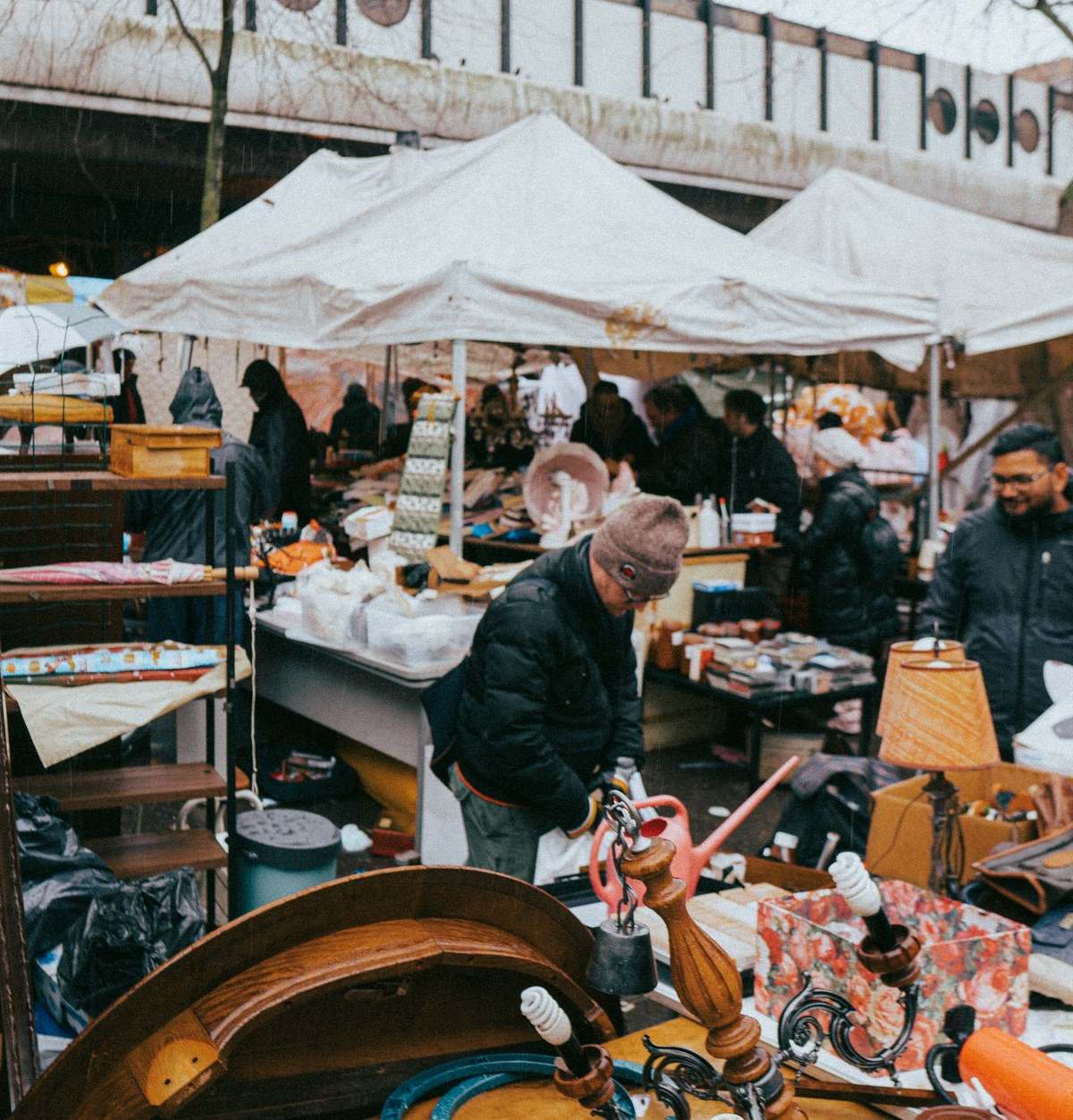 Explore the lively atmosphere of a Paris flea market on a chilly winter day, showcasing diverse stalls and shoppers.