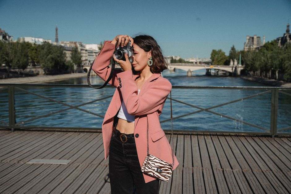 A traveler photographing Paris beside the Seine