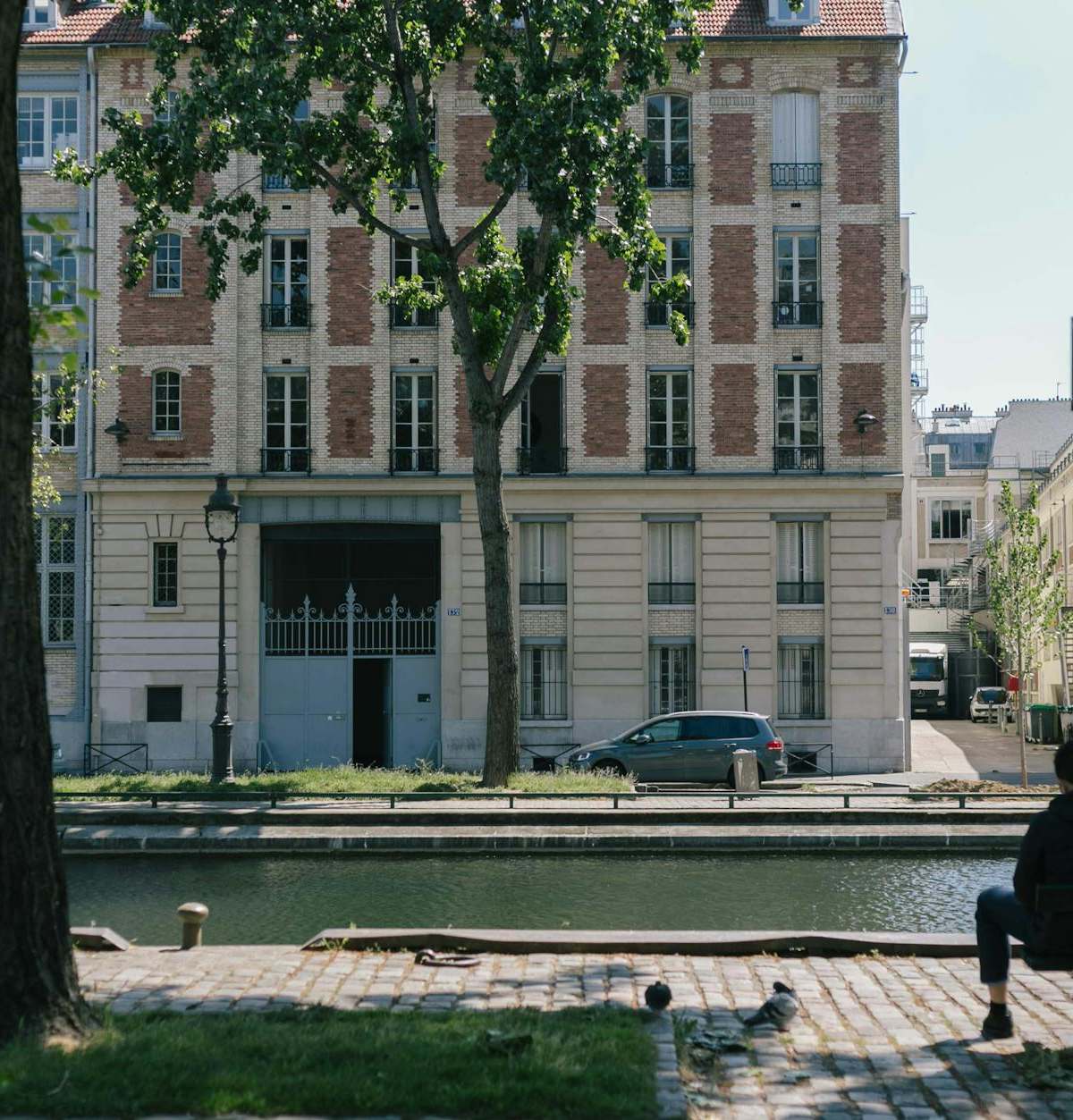 A serene view of Quai de Valmy in Paris with canal and classic architecture under clear skies.
