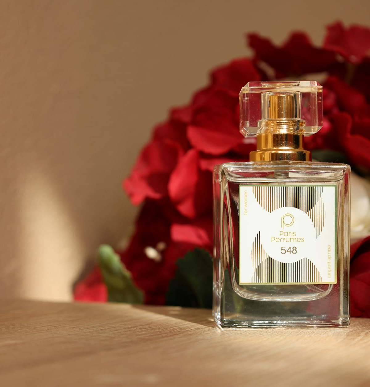 Elegant perfume bottle with red roses, embodying luxury and romance.