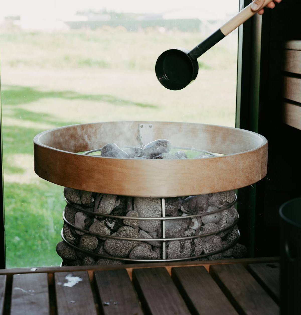 Water poured over sauna stones, illustrative wellness photograph
