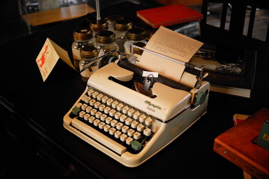 A vintage typewriter and notebooks, illustrative photograph
